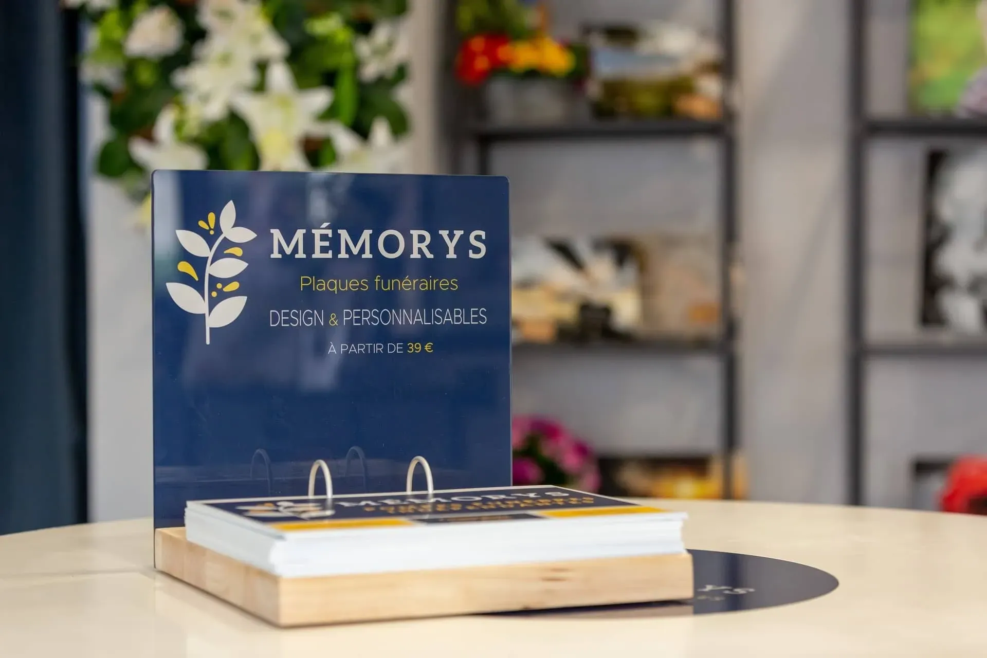 Présentoir de prospectus Mémorys proposant des plaques funéraires personnalisables à partir de 39 €.