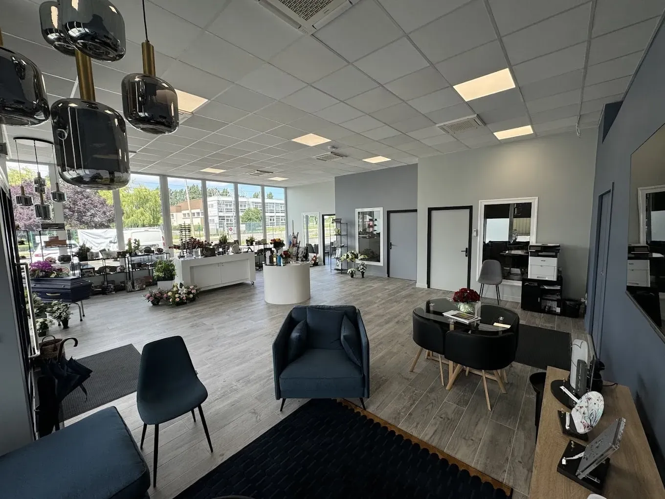 Espace d'accueil moderne avec salons de réception, mobilier contemporain et zone d'exposition.